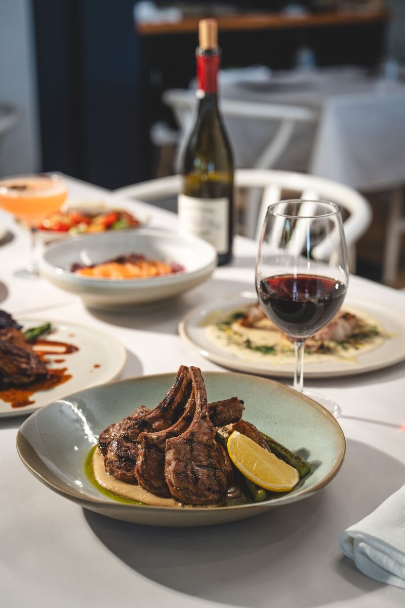 Lamb cutlets, dips and red wine in the dining room at OPA Echuca